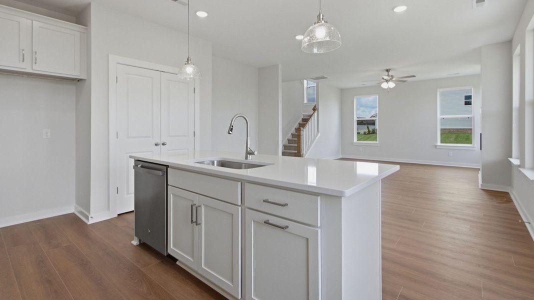 Kitchen with pantry, island, white cabinets, quartz countertop, and gas cooktop
