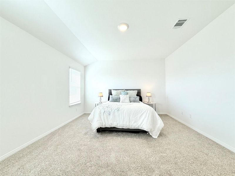Bedroom with light colored carpet and vaulted ceiling Bedroom with light colored carpet and vaulted ceiling