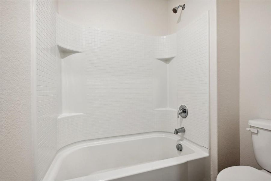 Bathroom featuring shower / washtub combination and toilet