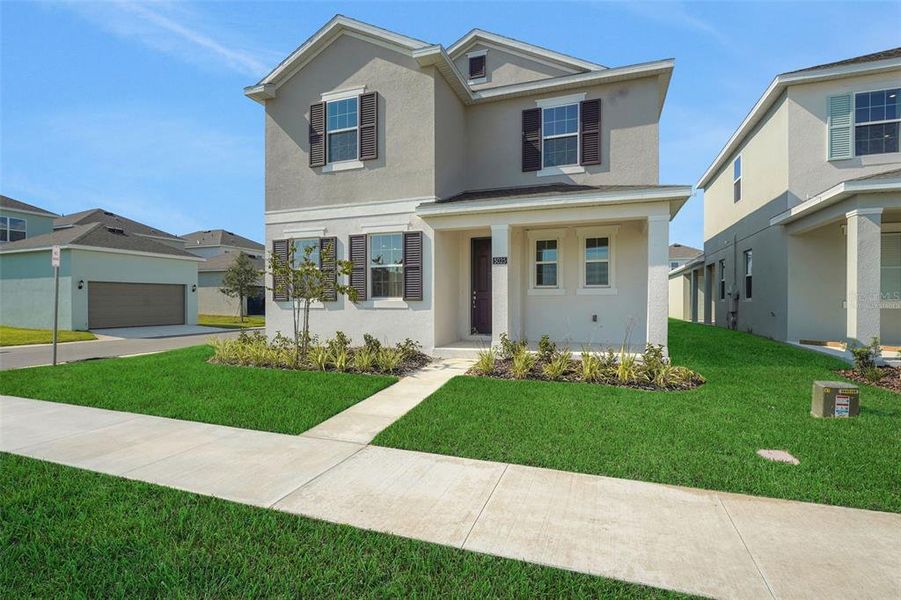 Front exterior of a new home in Crossroads at Kelly Park, Apopka, FL, highlighting curb appeal (Image 20). Front exterior of a new home in Crossroads at Kelly Park, Apopka, FL, highlighting curb appeal (Image 20).