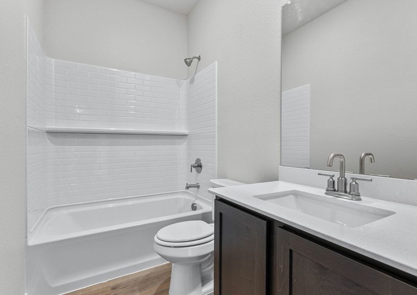 The secondary bathroom has a sprawling vanity and a shower-tub combo.