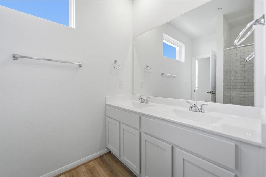 Full bath featuring double vanity and light wood-style floors Full bath featuring double vanity and light wood-style floors