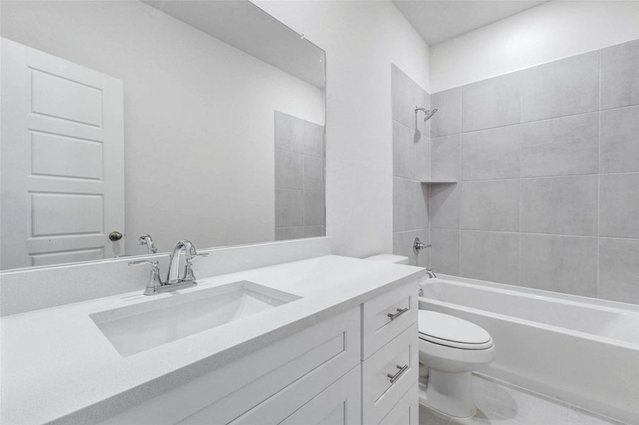 This bathroom offers a bright, clean design with a white vanity, sleek countertop, chrome fixtures, and a large mirror. The tub/shower combination features neutral tile surround and a built-in corner shelf, creating a simple and functional space with fresh finishes that feel easy to maintain. This bathroom offers a bright, clean design with a white vanity, sleek countertop, chrome fixtures, and a large mirror. The tub/shower combination features neutral tile surround and a built-in corner shelf, creating a simple and functional space with fresh finishes that feel easy to maintain.