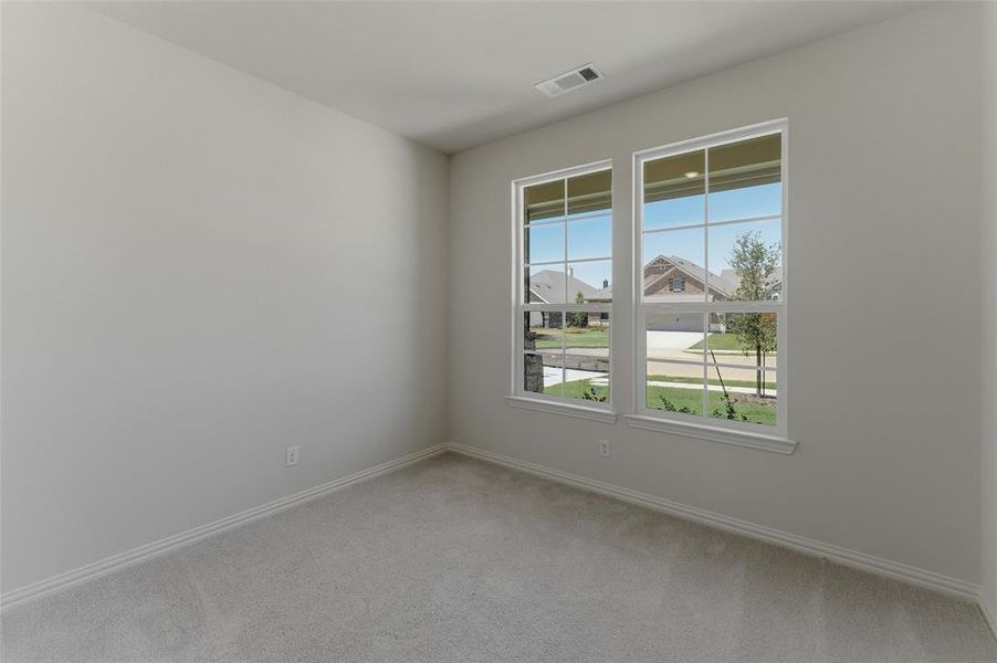 Neutral-toned room with white walls, light gray carpet flooring, and white baseboards