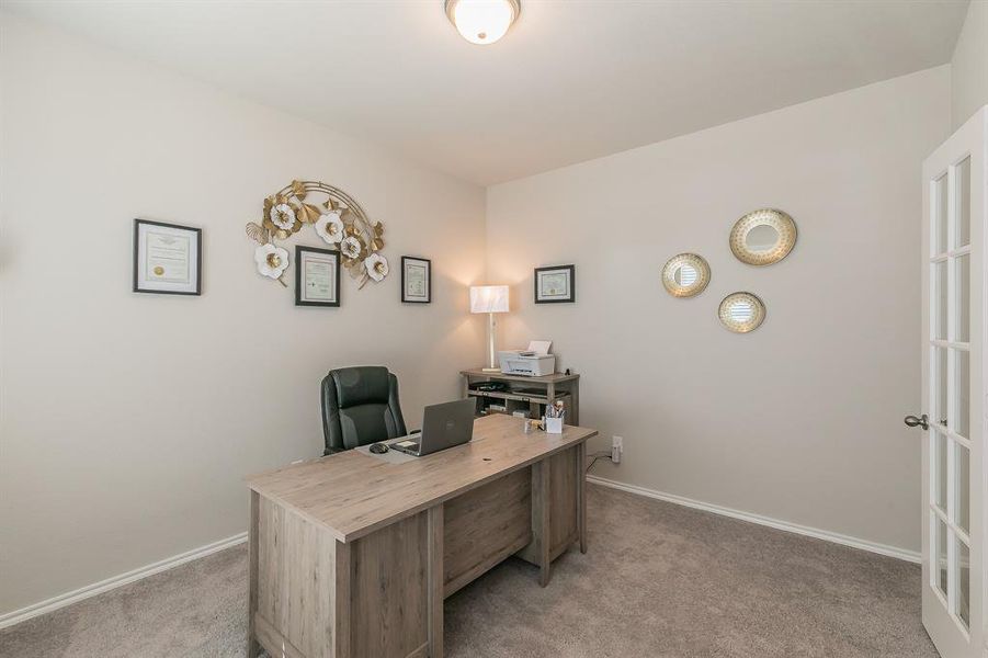 Home office with light carpet and baseboards