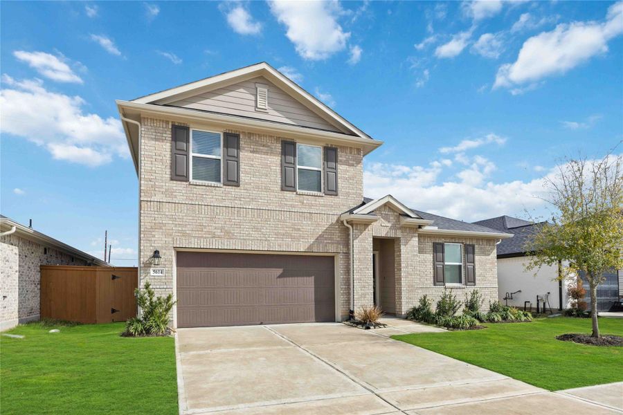 Front exterior of a new home in Sunterra, Katy, TX, highlighting curb appeal (Image 2).