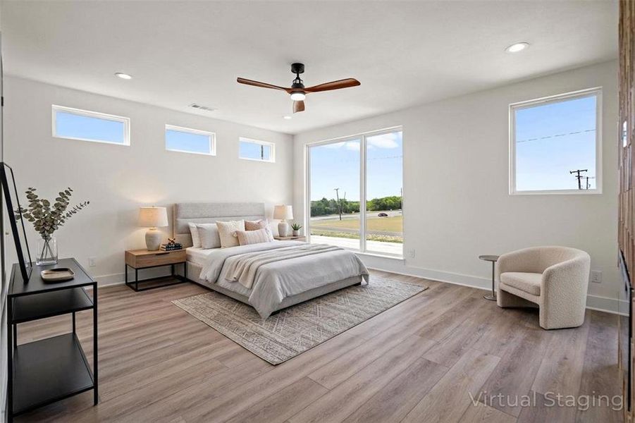 This bright room features wide plank flooring, a ceiling fan, and recessed lighting This bright room features wide plank flooring, a ceiling fan, and recessed lighting