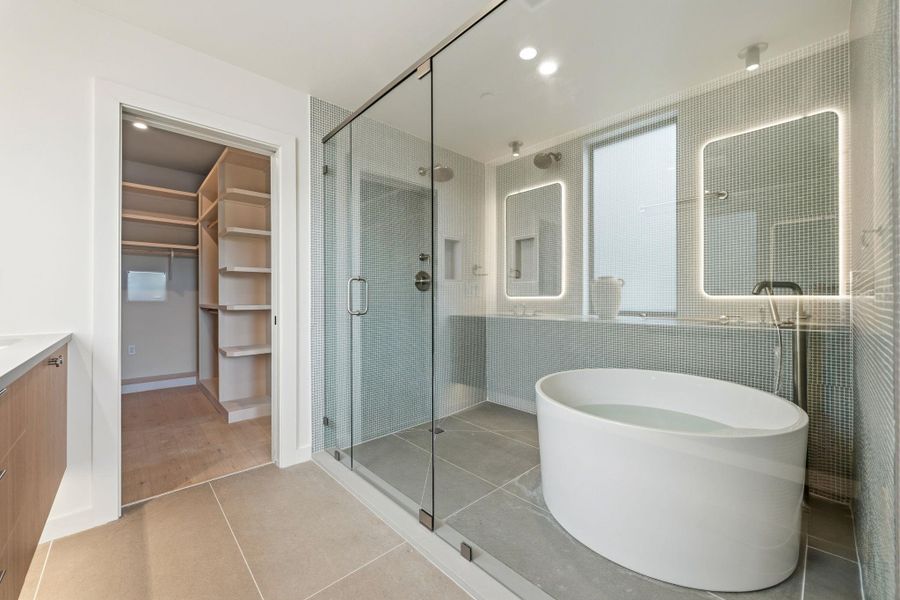 A private bathing sanctuary offers a glass-enclosed shower and a sleek, freestanding soaking tub. A private bathing sanctuary offers a glass-enclosed shower and a sleek, freestanding soaking tub.