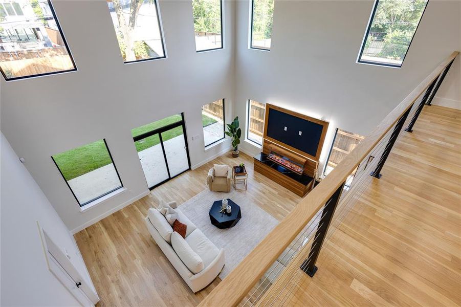 Living room with a towering ceiling and light hardwood / wood-style flooring