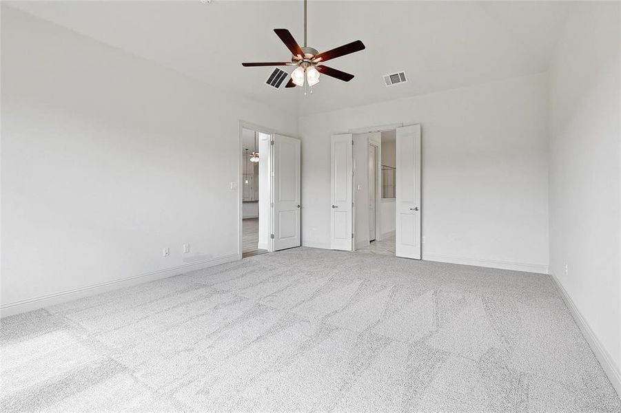 Unfurnished bedroom featuring light colored carpet, a ceiling fan, and ensuite bath