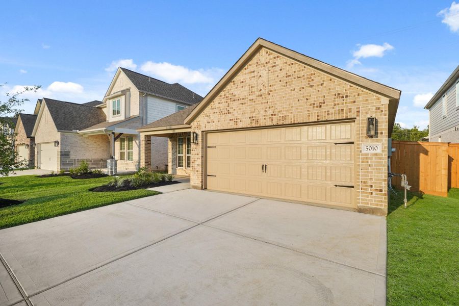 Front exterior of a new home in Sunterra North, Katy, TX, highlighting curb appeal (Image 12). Front exterior of a new home in Sunterra North, Katy, TX, highlighting curb appeal (Image 12).