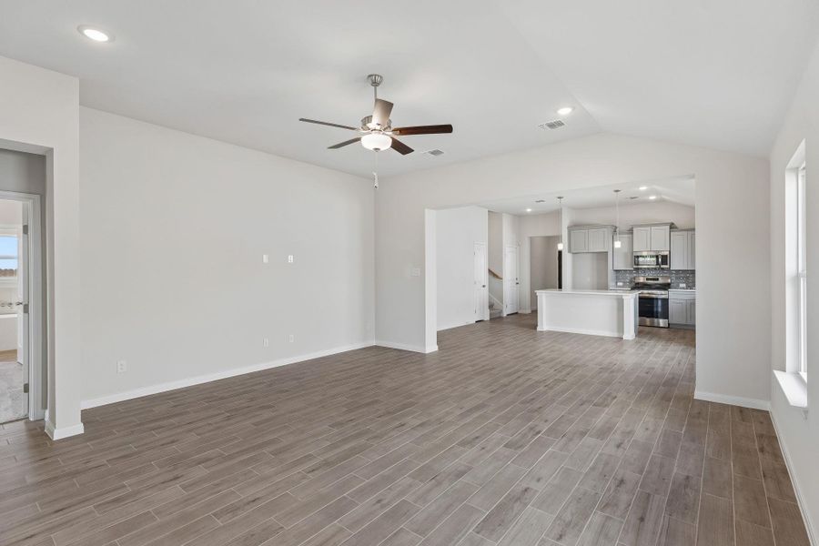 An open floorplan seamlessly connects the airy living area to the nearby kitchen.