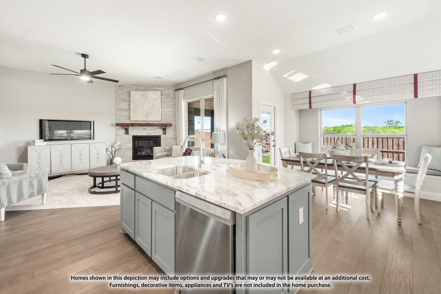 Open-concept kitchen with gray island and marble countertop, flowing into dining and living areas with fireplace and hardwood floors. Open-concept kitchen with gray island and marble countertop, flowing into dining and living areas with fireplace and hardwood floors.