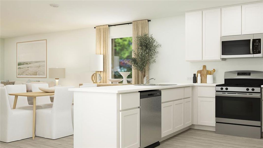 Kitchen featuring white cabinets, sink, light hardwood / wood-style flooring, kitchen peninsula, and stainless steel appliances