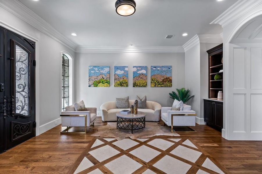 Living room with dark hardwood / wood-style floors and ornamental molding