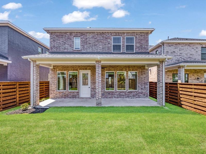Rear view of property with a patio area, brick siding, a fenced backyard, and roof with shingles