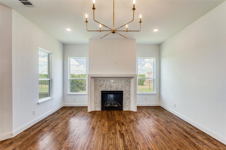 Unfurnished living room featuring a fireplace, dark hardwood / wood-style floors, and a wealth of natural light