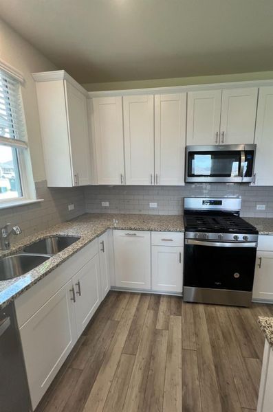 Kitchen has a huge pantry, white cabinets with sleek countertops and ample cabinetry for effortless meal preparation.