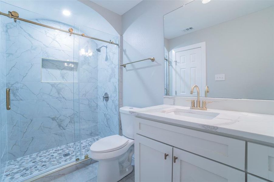 Bathroom featuring a marble finish shower and vanity Bathroom featuring a marble finish shower and vanity