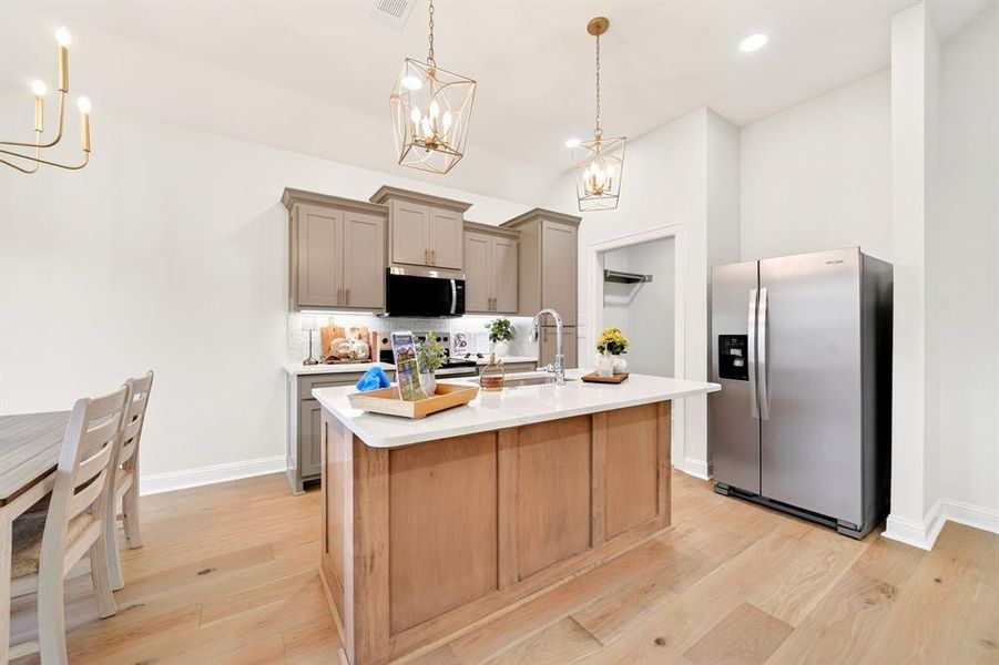 Modern kitchen featuring an island with a light-toned wood-finish base and a light-colored countertop