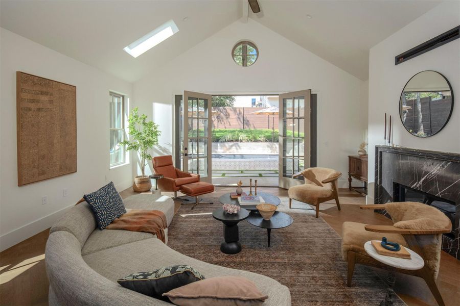 Double doors open to the patio, under vaulted ceilings and a bright skylight. Double doors open to the patio, under vaulted ceilings and a bright skylight.