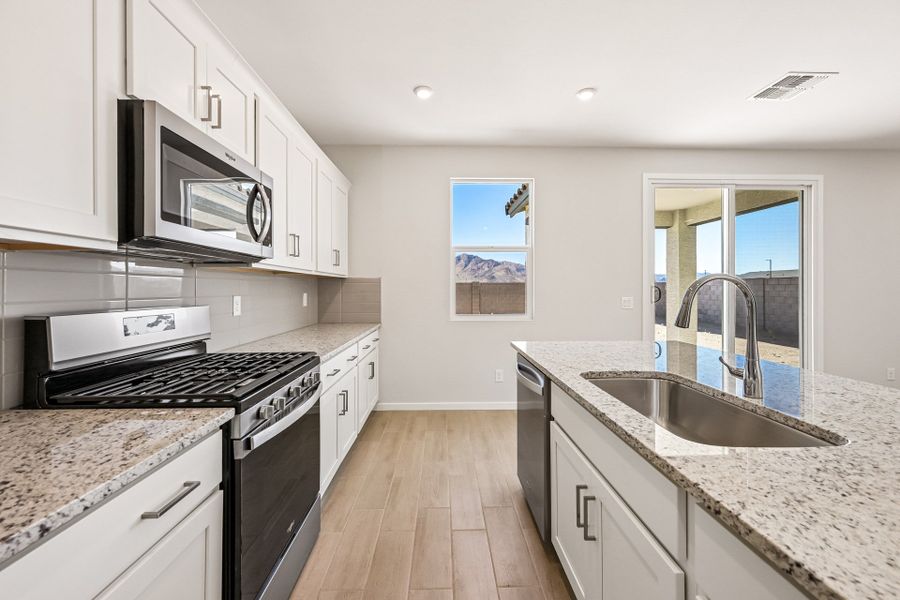 A kitchen with white cabinets.