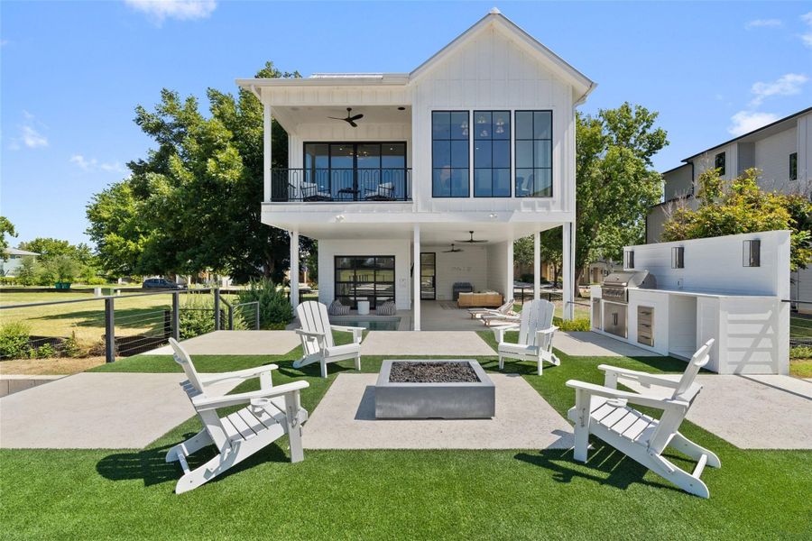 An inviting backyard oasis offers a built-in fire pit, outdoor kitchen, and an elevated balcony for entertaining. An inviting backyard oasis offers a built-in fire pit, outdoor kitchen, and an elevated balcony for entertaining.