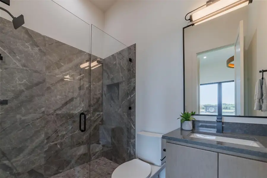 Full bathroom with a marble finish shower and vanity