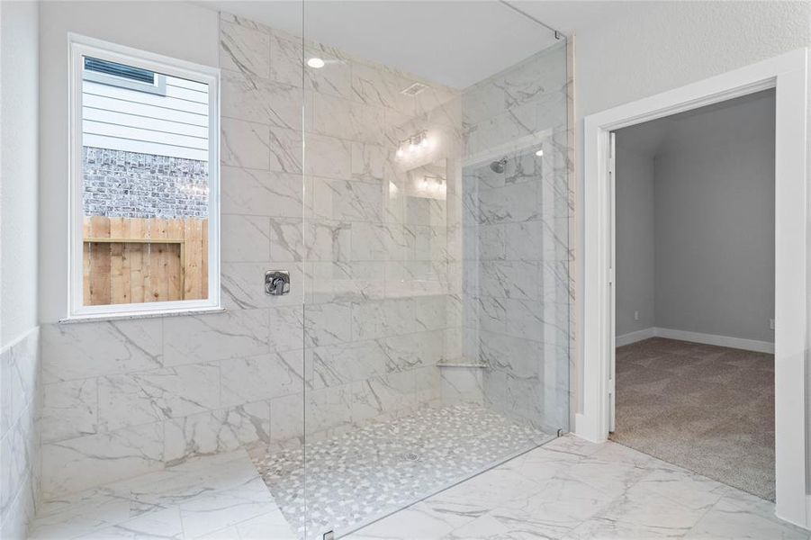 Additional view of this primary bathroom features this oversized walk-in shower with tile surround.