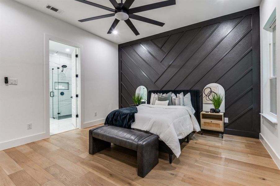 Bedroom with light wood-style flooring, a ceiling fan, and connected bathroom Bedroom with light wood-style flooring, a ceiling fan, and connected bathroom