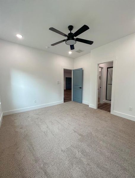 Unfurnished bedroom featuring carpet floors and ceiling fan