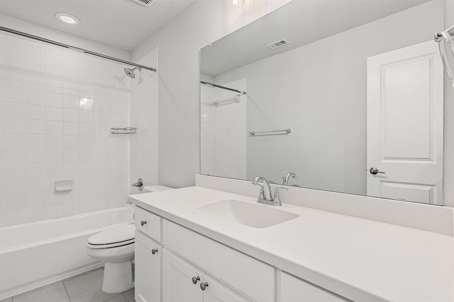 Full bathroom with tile flooring, tiled shower / bath, and large vanity