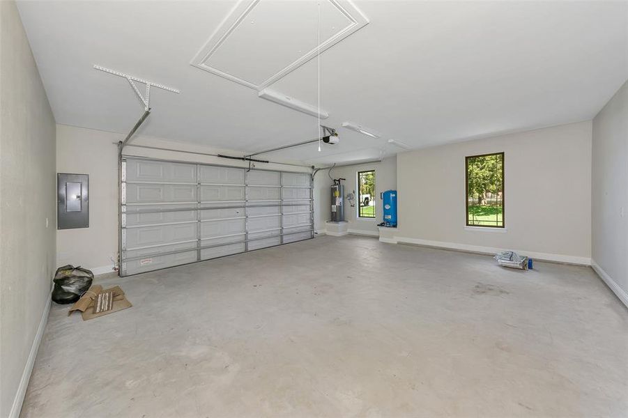 Garage with electric panel, a garage door opener, and water heater