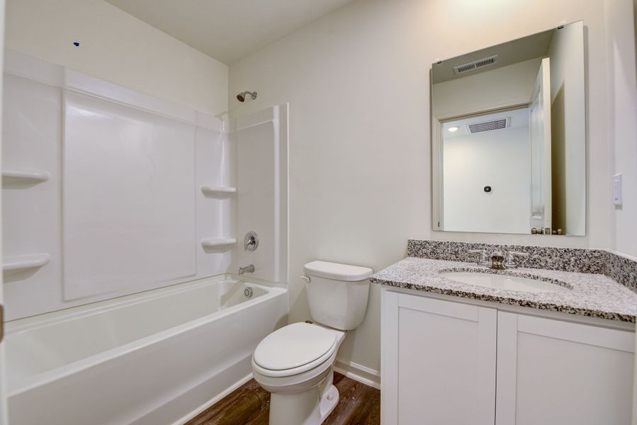A bathroom with a tub toilet and sink.