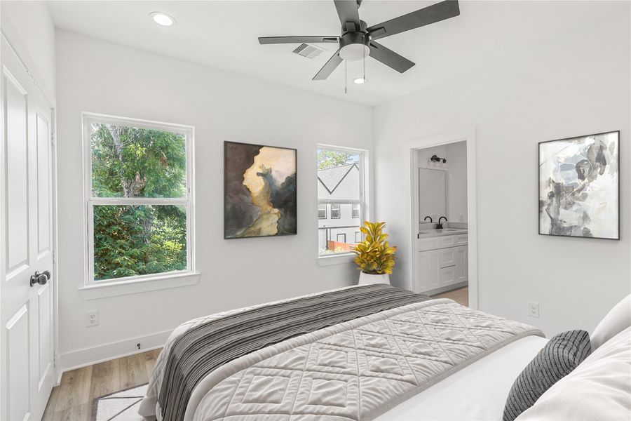 Bright and spacious second bedroom featuring large windows that fill the room with natural light and a ceiling fan for added comfort. Complete with a private ensuite bathroom, this room offers the perfect blend of privacy and convenience for family or guests. Photo is virtually staged.