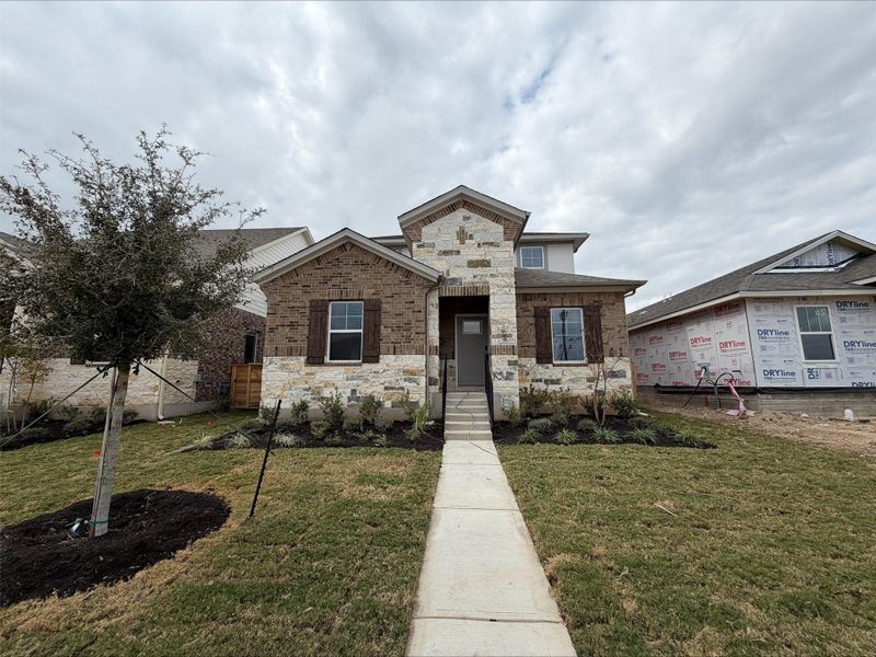 View of front facade with stone siding and a front lawn View of front facade with stone siding and a front lawn