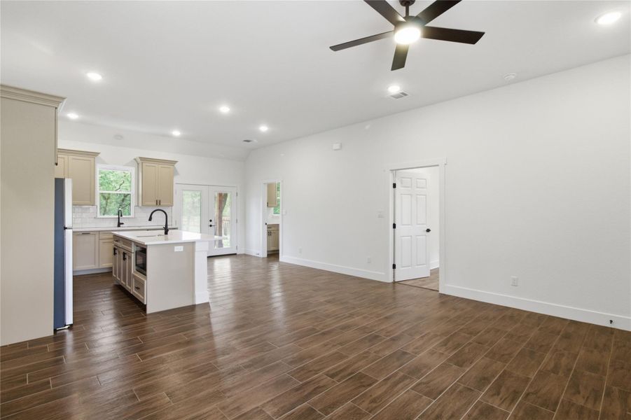 An open-concept living area boasts sleek flooring, recessed lighting, and a modern kitchen island with integrated appliances. An open-concept living area boasts sleek flooring, recessed lighting, and a modern kitchen island with integrated appliances.
