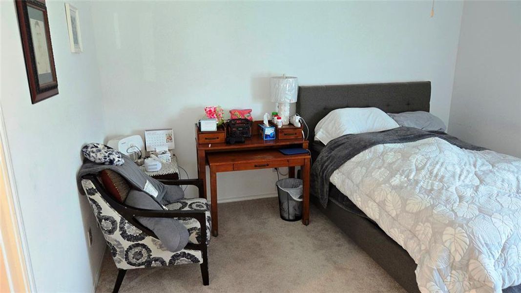 Carpeted bedroom featuring white walls and a built-in ceiling fan