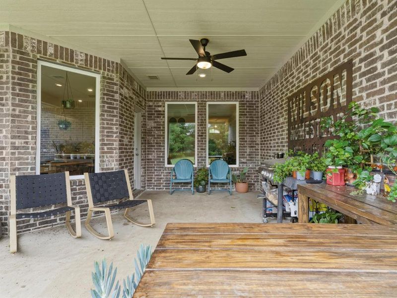 Covered back porch with extended concrete patio, ideal for outdoor dining, relaxing, and entertaining.