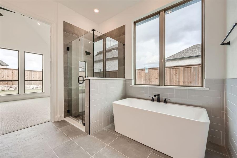 Bathroom featuring tile walls, independent shower and bath, tile patterned flooring, and plenty of natural light