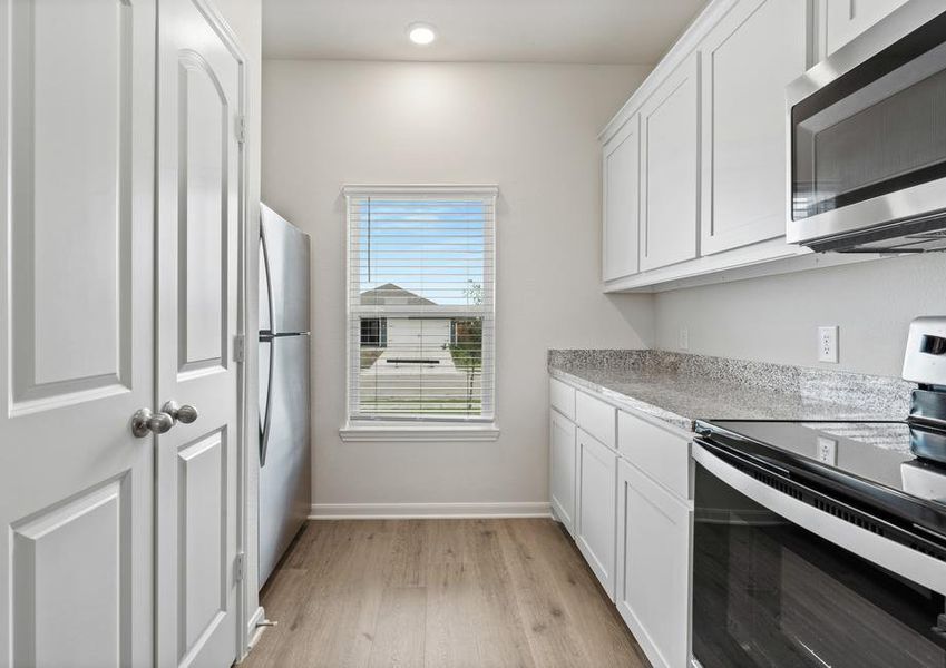 The kitchen of the Driftwood has beautiful white wood cabinets.