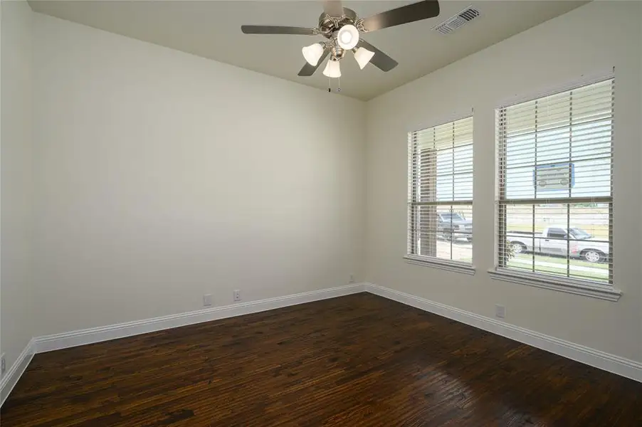 Empty room with hardwood / wood-style flooring and ceiling fan