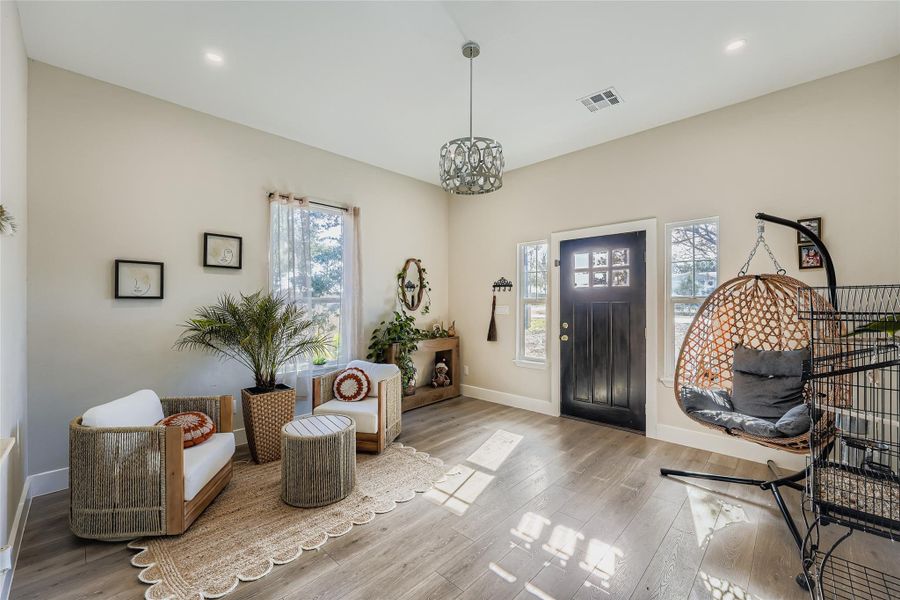 Entrance foyer with wood finished floors, a chandelier, and recessed lighting Entrance foyer with wood finished floors, a chandelier, and recessed lighting