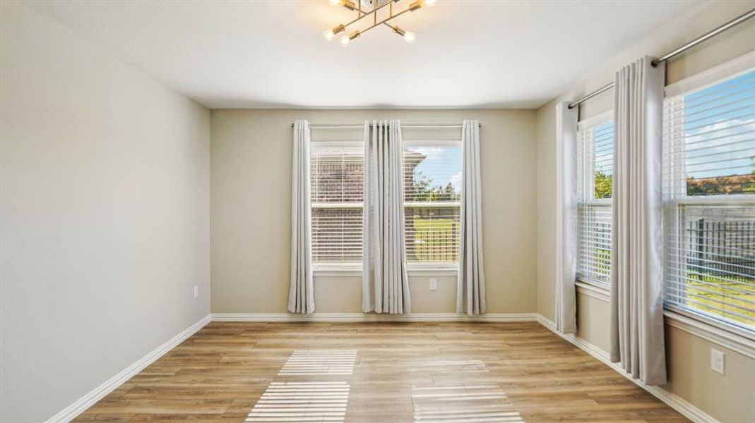 Unfurnished room featuring light wood-style floors and a chandelier Unfurnished room featuring light wood-style floors and a chandelier