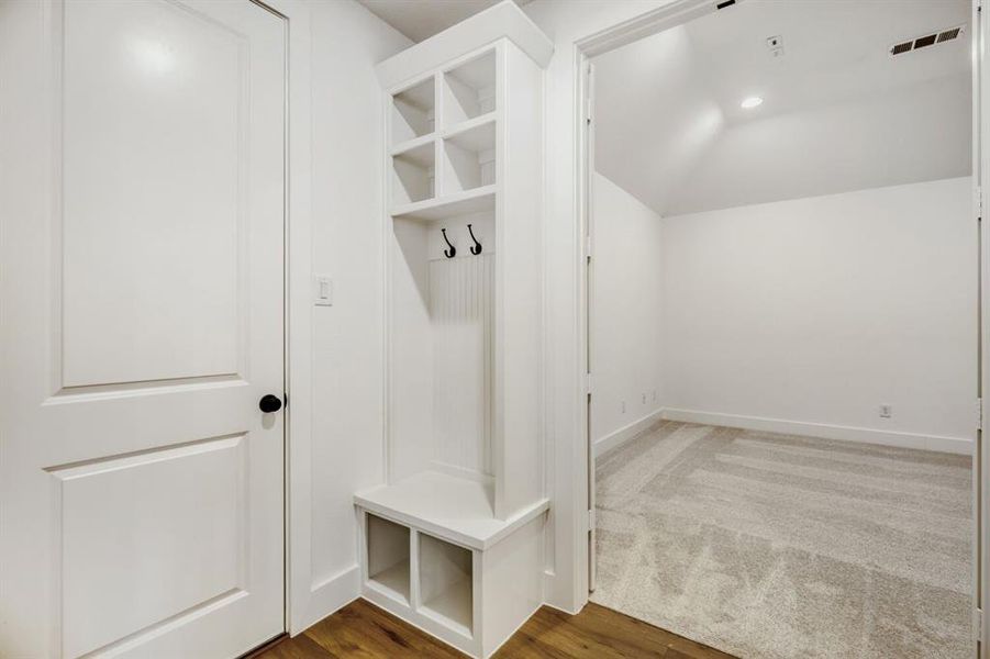 Mudroom with lofted ceiling, light wood-style flooring, and recessed lighting