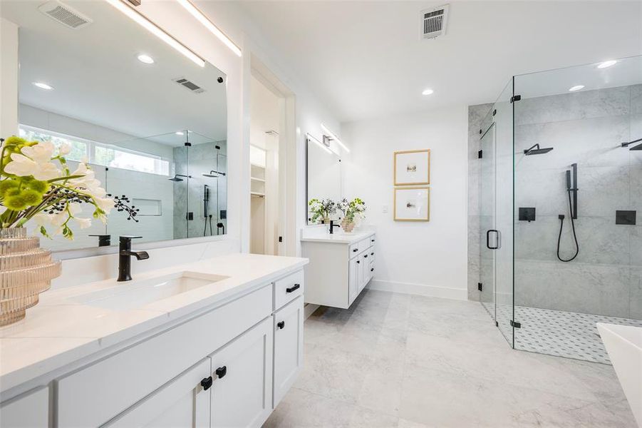 Full bath featuring two vanities, a stall shower, recessed lighting, and a freestanding bath Full bath featuring two vanities, a stall shower, recessed lighting, and a freestanding bath