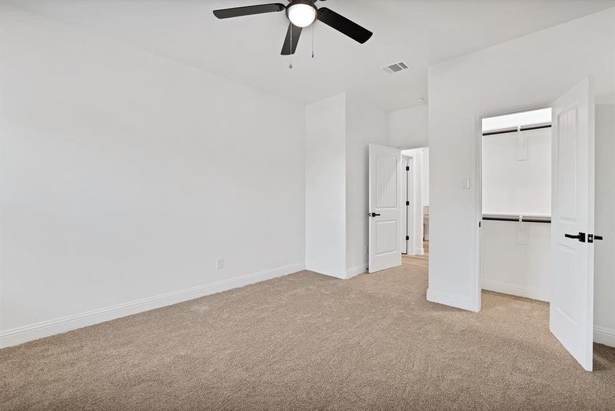 Unfurnished bedroom featuring light carpet, a closet, and ceiling fan