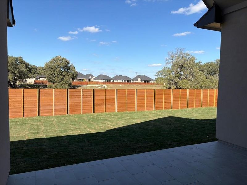 Fenced backyard with a patio area and a residential view Fenced backyard with a patio area and a residential view