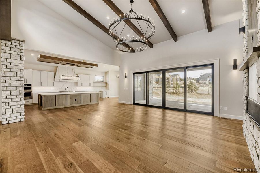 Great room with beamed ceiling opening to kitchen