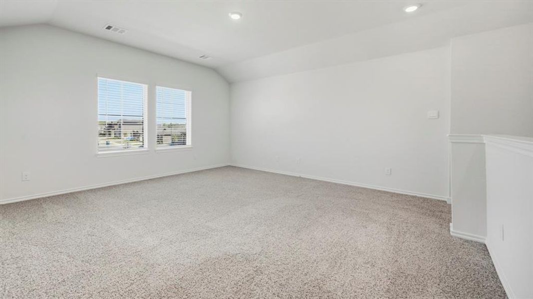 Unfurnished room featuring light colored carpet, vaulted ceiling, and recessed lighting